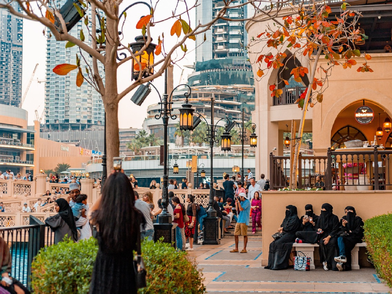 Bustling urban street scene at sunset with diverse groups of people